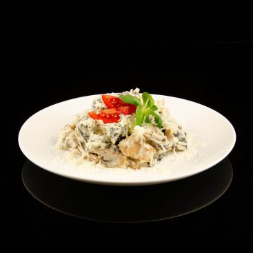 Creamy chicken and mushroom salad topped with grated cheese, tomato wedges and fresh basil