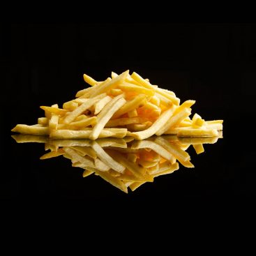 Golden french fries piled on a black surface with a mirror reflection