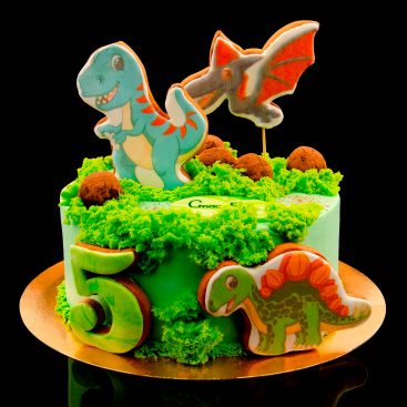 Green birthday cake with dinosaur gingerbread toppers, chocolate truffles and a number five