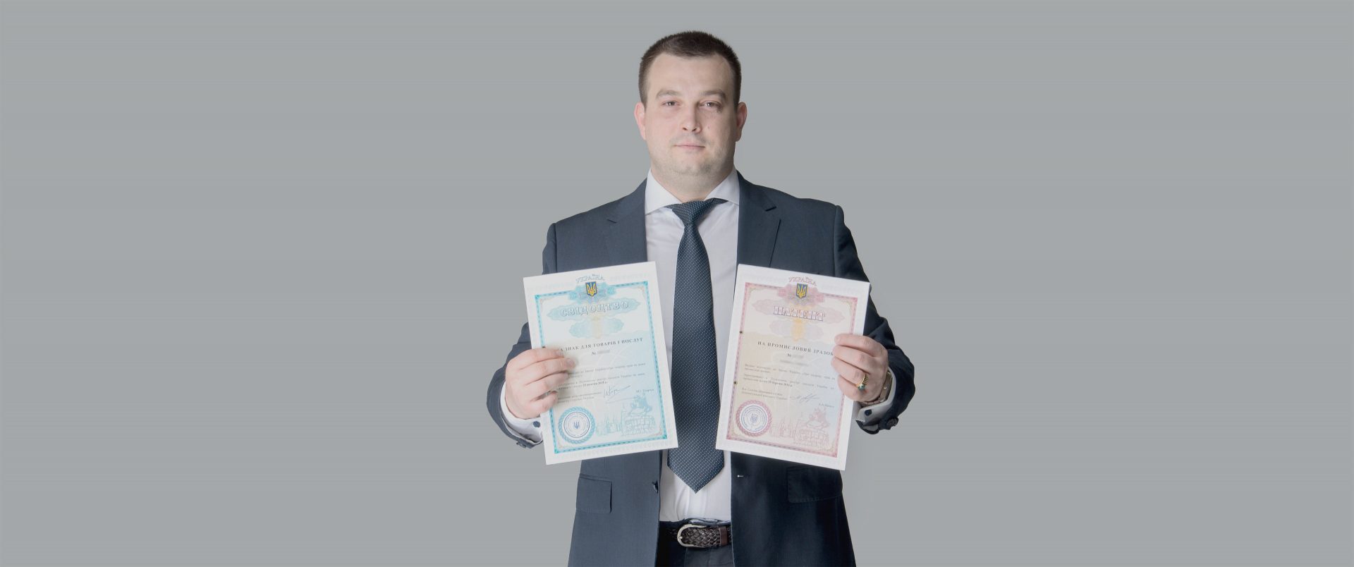 A trademark certificate and an industrial design patent, held up side by side